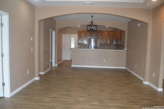 18687 Rolling Mdw, Lytle, TX 78052 - interior space featuring light wood finished floors, stainless steel appliances, a peninsula, visible vents, and baseboards
