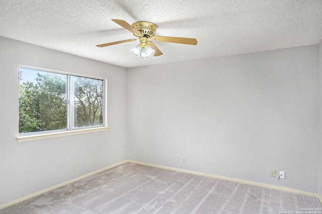 empty room with a ceiling fan, baseboards, and light colored carpet