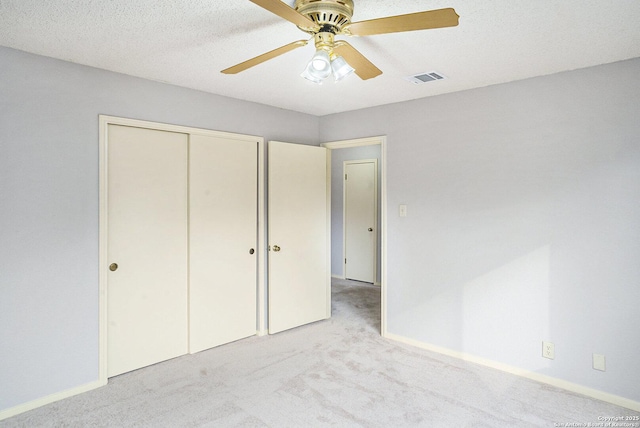 unfurnished bedroom with visible vents, carpet, a closet, and ceiling fan