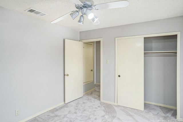 unfurnished bedroom featuring carpet, visible vents, a ceiling fan, a closet, and baseboards