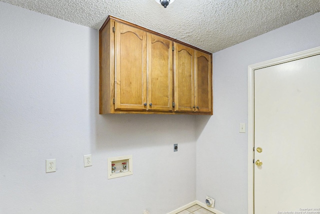 laundry room with baseboards, electric dryer hookup, cabinet space, washer hookup, and a textured ceiling