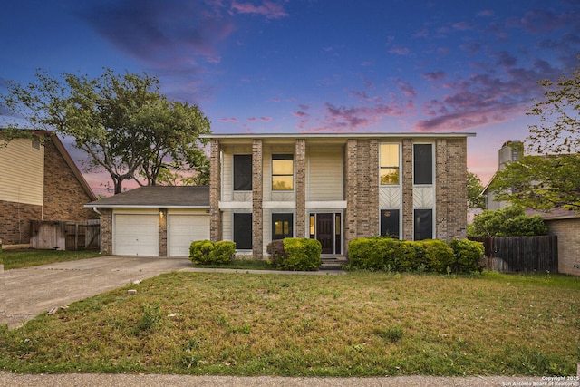 view of front of house with a front lawn, concrete driveway, fence, a garage, and brick siding