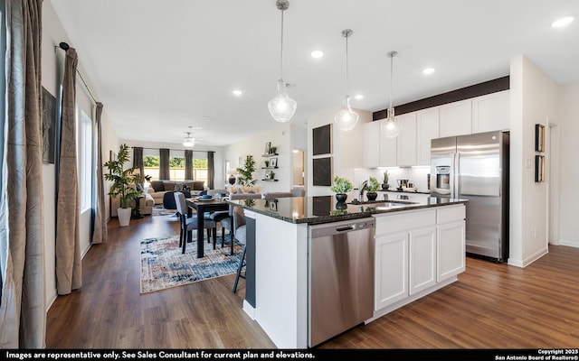 kitchen featuring a sink, appliances with stainless steel finishes, a kitchen island with sink, recessed lighting, and dark wood-type flooring