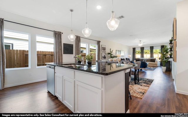 kitchen featuring a sink, visible vents, dishwasher, and dark wood finished floors