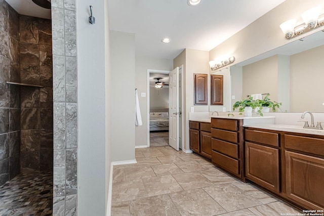 ensuite bathroom featuring double vanity, ceiling fan, connected bathroom, a walk in shower, and a sink
