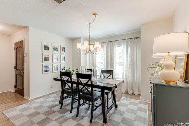 dining room with baseboards, light wood-style floors, a notable chandelier, and visible vents