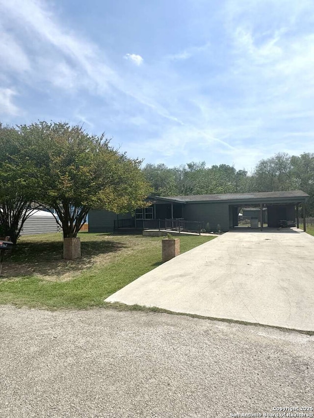 view of front of property with driveway, a front lawn, and a carport