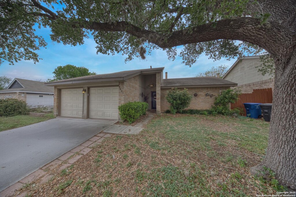 9627 Wildwood Rdg, San Antonio, TX 78250 - view of front of property featuring fence, an attached garage, driveway, brick siding, and a front yard