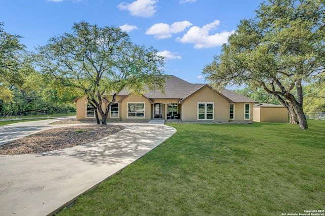 single story home featuring a front yard, a shingled roof, concrete driveway, and stucco siding