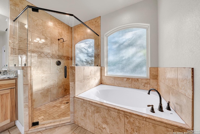 bathroom with a bath, a shower stall, vanity, and tile patterned floors