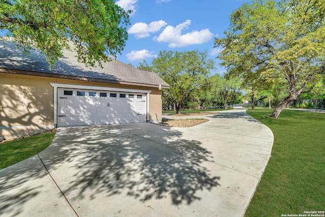 view of side of property featuring a yard, a shingled roof, and concrete driveway