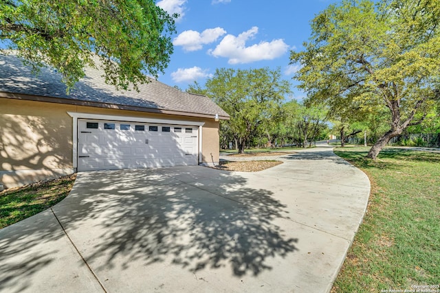 view of property exterior with driveway, roof with shingles, a yard, and a garage