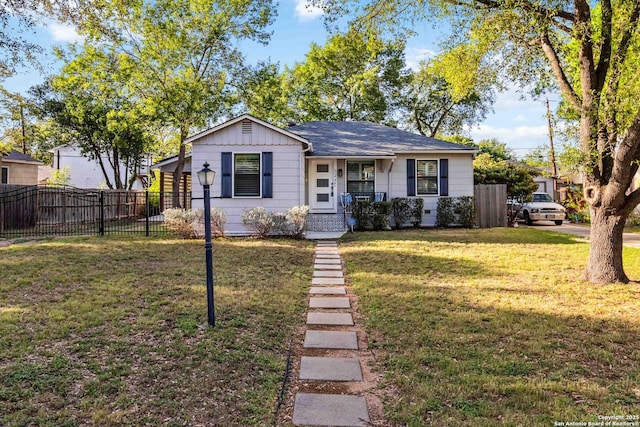 bungalow-style house with fence, covered porch, and a front yard