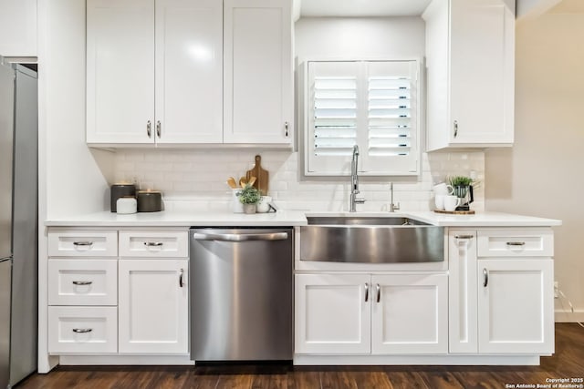 kitchen with white cabinets, stainless steel appliances, light countertops, and backsplash