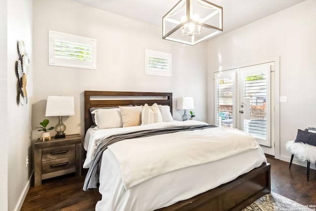 bedroom featuring dark wood finished floors, access to outside, baseboards, and a notable chandelier