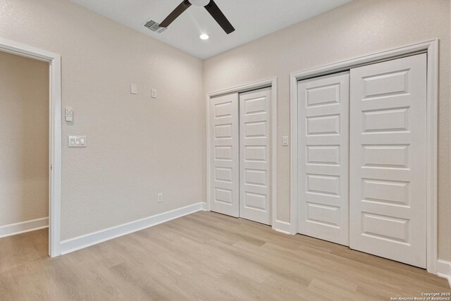 114 S Minter St, San Antonio, TX 78207 - unfurnished bedroom with light wood finished floors, baseboards, multiple closets, and visible vents