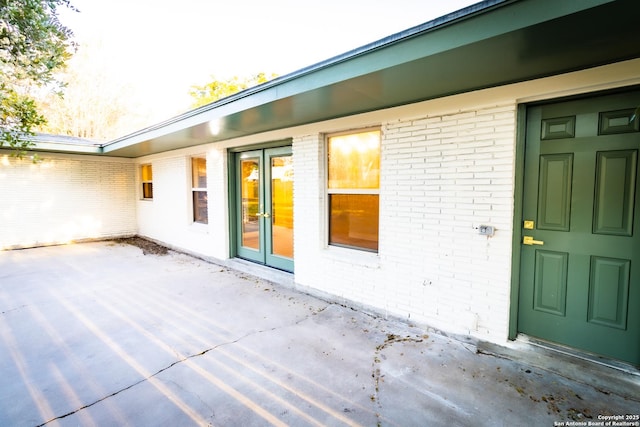 905 E Inez, Beeville, TX 78102 - view of exterior entry featuring brick siding and a patio