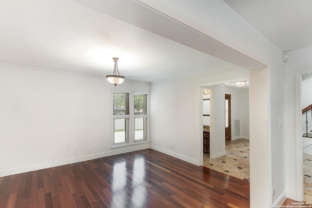 unfurnished room with baseboards, crown molding, wood finished floors, and visible vents