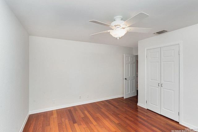 unfurnished bedroom featuring baseboards, wood finished floors, visible vents, and a closet