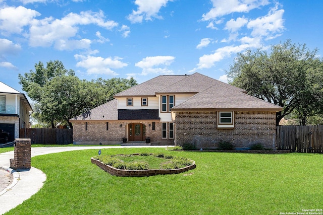 view of front of property with brick siding, a front lawn, and fence