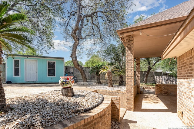 view of patio with an outdoor structure and a fenced backyard