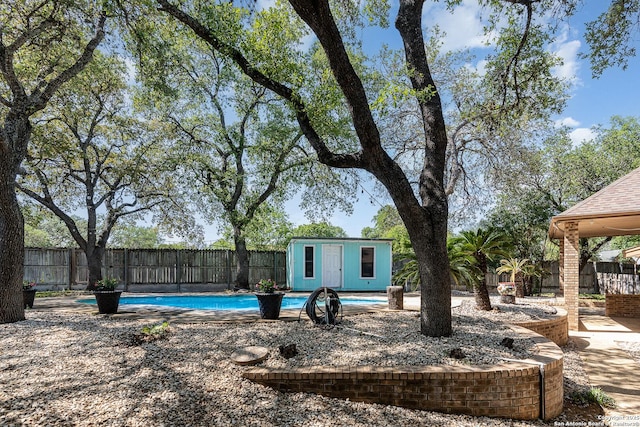 view of yard with a fenced backyard, an outbuilding, and a fenced in pool