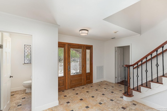 entrance foyer featuring baseboards, visible vents, stairs, and ornamental molding