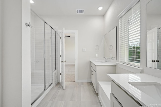 6031 Calgary Park, San Antonio, TX 78233 - bathroom featuring a stall shower, two vanities, and recessed lighting