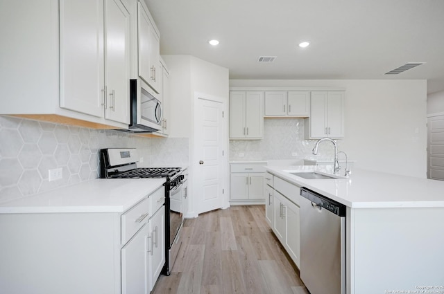 6031 Calgary Park, San Antonio, TX 78233 - kitchen featuring stainless steel appliances, a sink, light wood-style floors, a center island with sink, and white cabinets