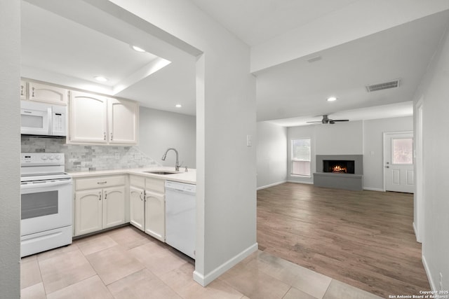 kitchen with a sink, visible vents, recessed lighting, backsplash, and white appliances