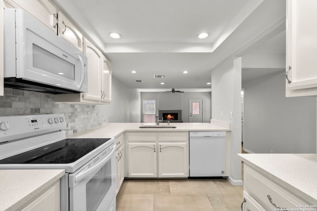 kitchen with recessed lighting, white cabinets, light countertops, white appliances, and decorative backsplash