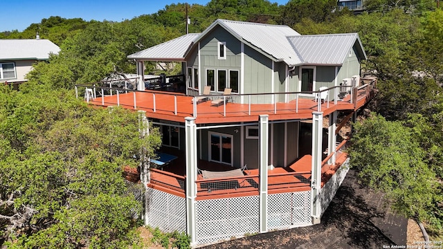 rear view of house featuring metal roof and a deck