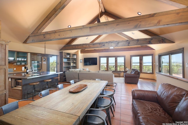 dining space featuring lofted ceiling with beams and light tile patterned flooring