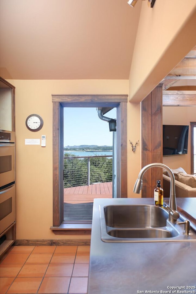 kitchen featuring tile patterned floors, a sink, and double oven