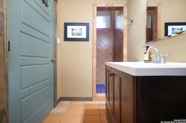 bathroom with tile patterned floors, baseboards, and vanity