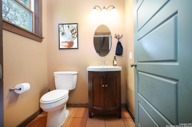 bathroom with toilet, vanity, and tile patterned floors