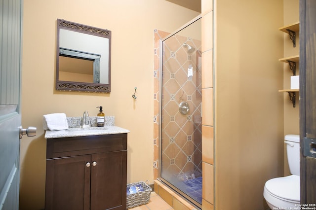 bathroom with a shower stall, toilet, and vanity