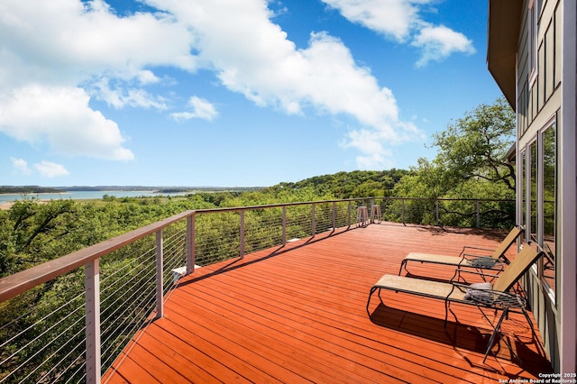 deck with a forest view and a water view