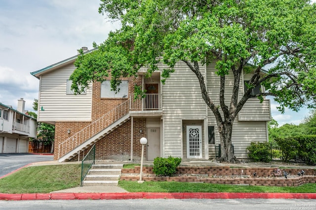 view of front of house featuring stairway and aphalt driveway