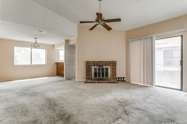 unfurnished living room with a textured ceiling, visible vents, carpet, a ceiling fan, and a brick fireplace