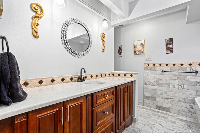 full bath with vanity, tile walls, marble finish floor, walk in shower, and visible vents