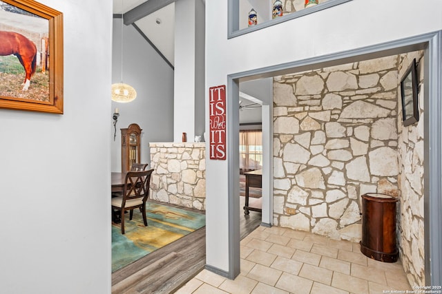 foyer featuring tile patterned flooring, high vaulted ceiling, and a chandelier