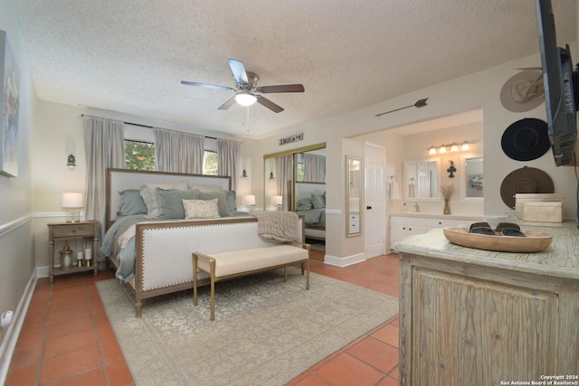 bedroom with a ceiling fan, ensuite bath, a textured ceiling, and light tile patterned flooring