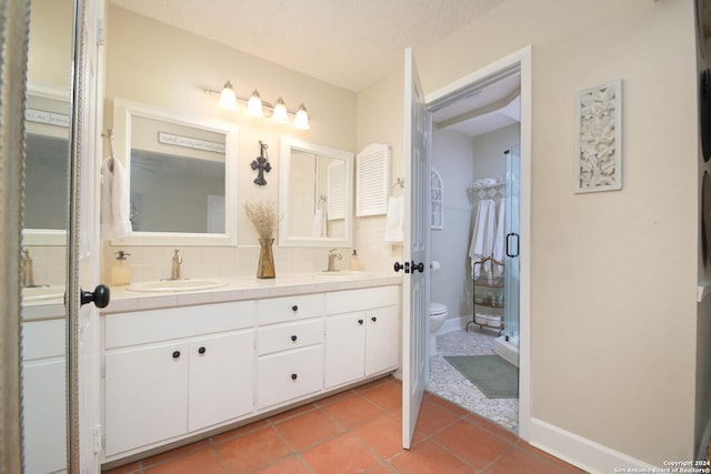 full bath with toilet, tasteful backsplash, a sink, and double vanity