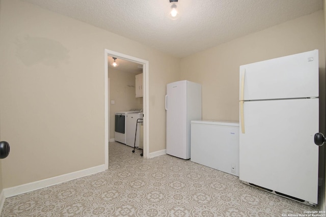 washroom with washer and clothes dryer, a textured ceiling, light floors, cabinet space, and baseboards