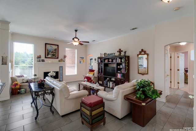 1106 Crystal Spg, San Antonio, TX 78258 - living room featuring visible vents, arched walkways, baseboards, a fireplace, and ceiling fan