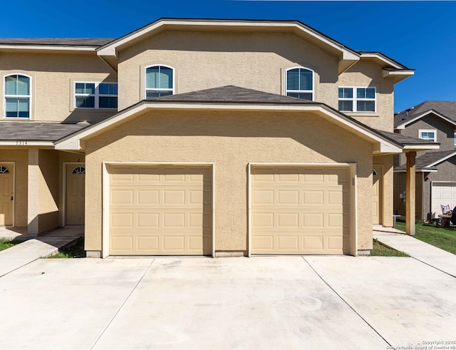 view of front of property with stucco siding, a garage, and concrete driveway