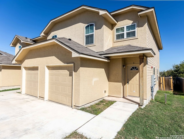 traditional home with driveway, stucco siding, and fence