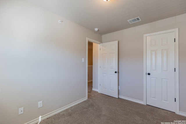 unfurnished bedroom with visible vents, carpet flooring, and baseboards