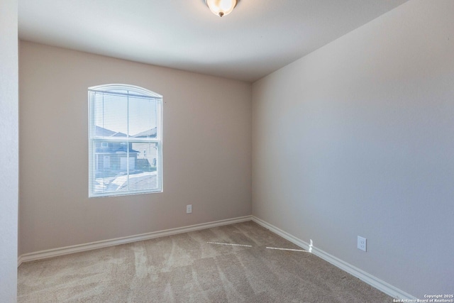 unfurnished room featuring baseboards and carpet